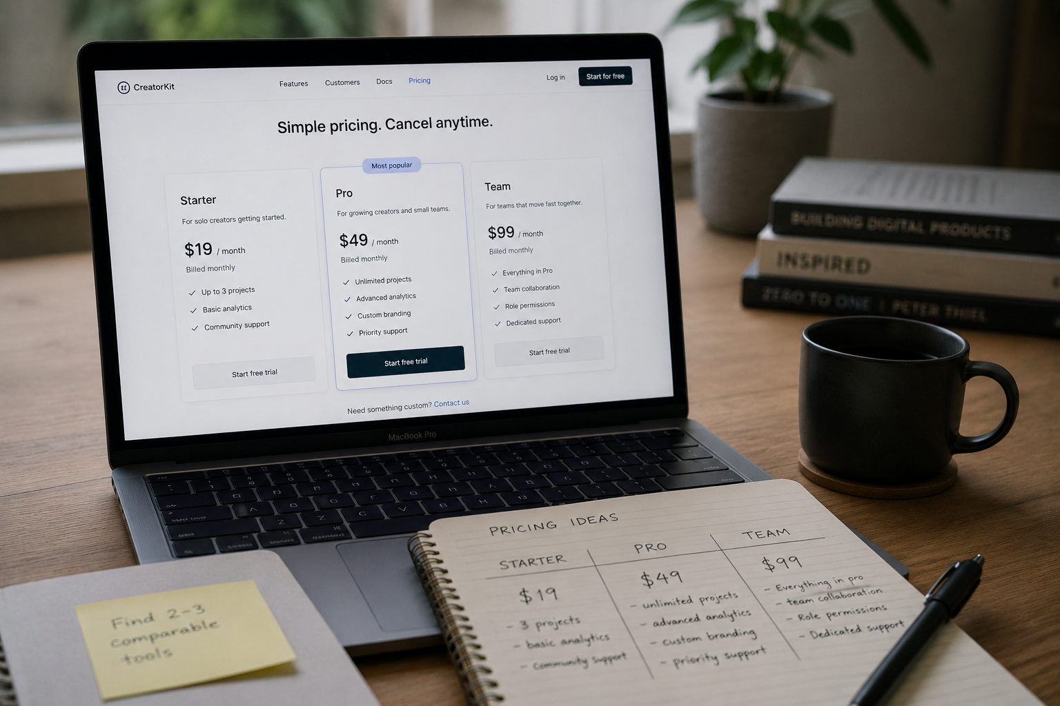 A laptop screen showing three pricing plan cards side by side, soft desk lighting