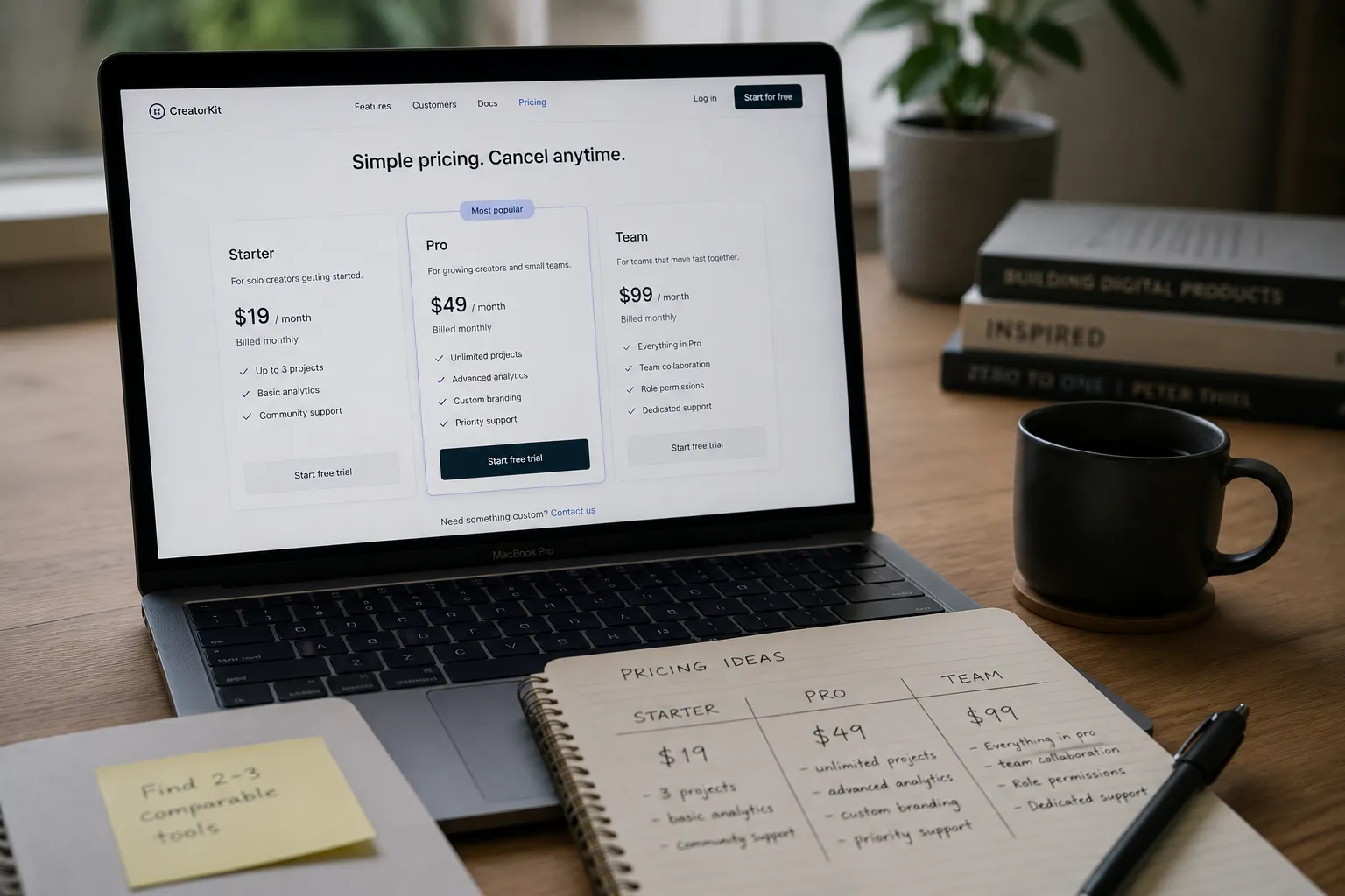 A laptop screen showing three pricing plan cards side by side, soft desk lighting